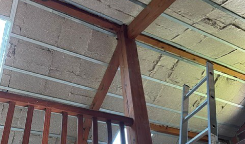 Détail de la retombée de plâtre sur une panne de charpente, aménagement sur mesure à Cambo-les-Bains