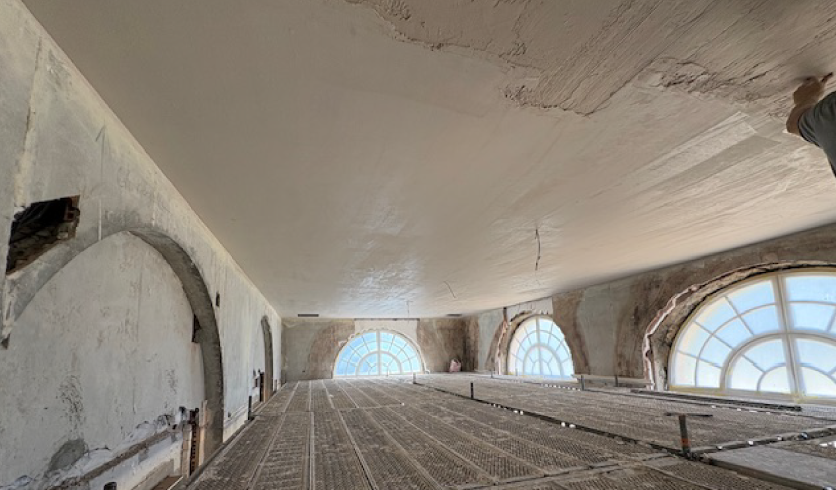 Artisan plâtrier Aizpuru Eneko en plein lissage d'un enduit de plâtre traditionnel au plafond